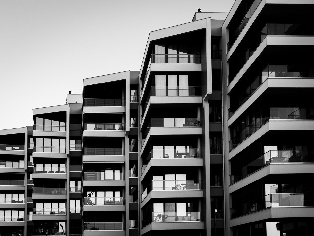 Striking black and white photo of a modern apartment building facade with geometric design.